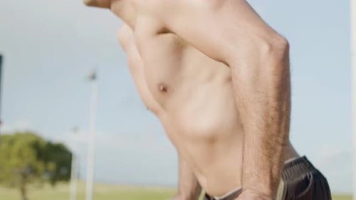 Man with Naked Torso Doing Exercises on Bar