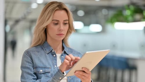 Young Woman Uses Tablet in Modern Workplace