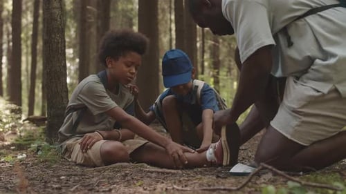 Adult Tends to Injured Child in Forest