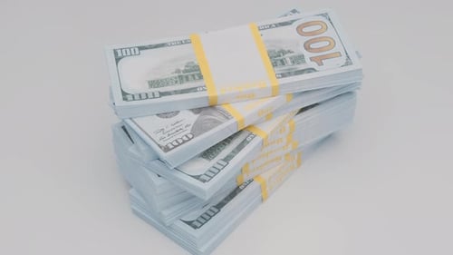 stack of bank bundles with dollars rotating on white background