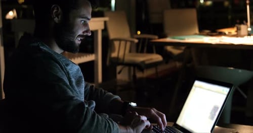 Man Working on Laptop at Night