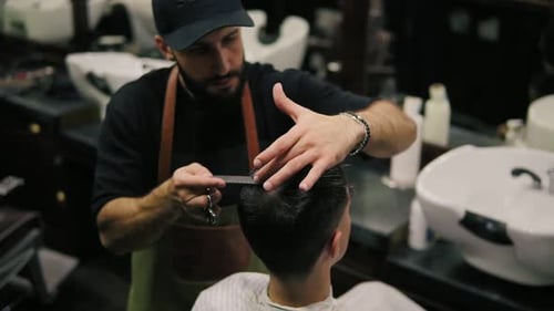 Bearded Barber Cuts Man's Hair with Scissors