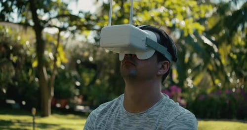 A Man in a Virtual Reality Helmet is Studying a Virtual Game