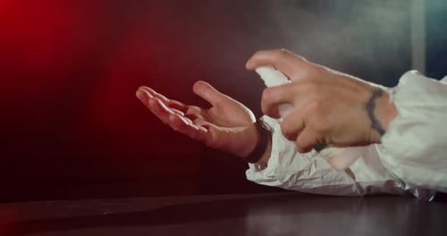 Person in Protective Suit Sanitizes Hand