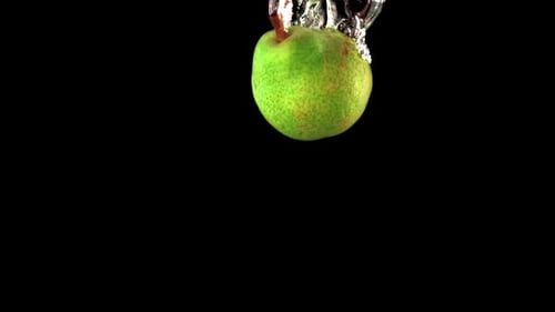 Super Slow Motion One Green Pear Falls Under the Water with Air Bubbles