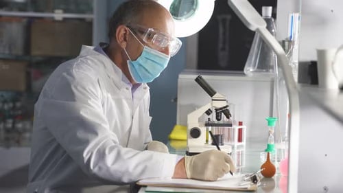 Man Writes Notes In A Medical Research Lab