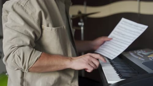 Person Plays Electric Piano with Sheet Music