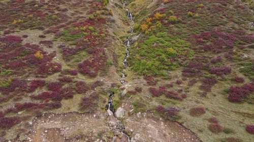 Aerial view of waterfall in rocky high mountains in cloud weather