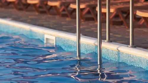 Top View of Swimming Pool with Clear Water on Vacation on Sunset Background