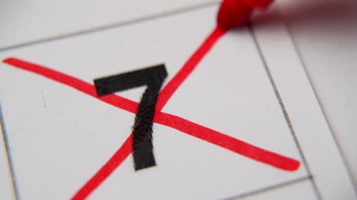 El 7º número del calendario está tachado con una cruz roja en una macro en una hoja blanca