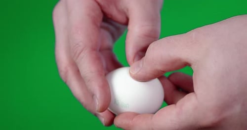 Men's Hands with a Knife Break Raw Egg.