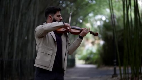 Handsome Man is Playing Violin in Garden in Summer Romantic Musician Play Fiddle Outdoor