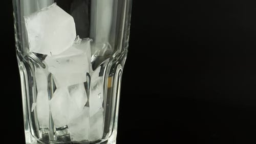 Ice Cubes Falling Into a Glass