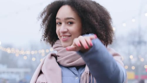 Smiling Young Woman Waving to the Camera