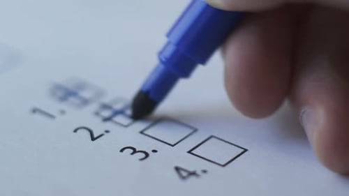 Blue Marker Filling in Checklist Boxes