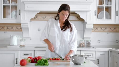 Woman Chopping Vegetables in Bright Kitchen