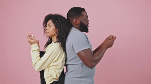 Unsicherer afroamerikanischer Mann und Frau stehen Rücken an Rücken und vergleichen Varianten und zählen auf Finger