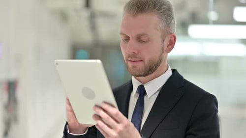 Professional Man Using Tablet in Office Setting