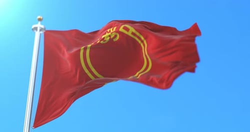 Realistic Red Flag with Yellow Symbol Waving in Blue Sky