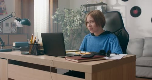 A Child Attending an Elementary School Has a Lesson with a Teacher Remotely Via the Internet the