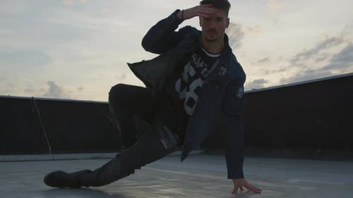Breakdancer Performing on City Rooftop at Sunset