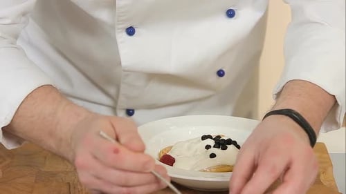 Chef Decorates Dessert with Fresh Berries and Sugar