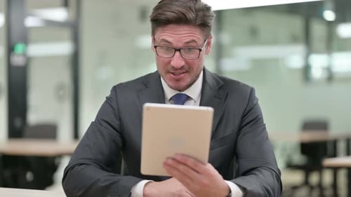 Business Man Video Conferencing on Tablet in Office