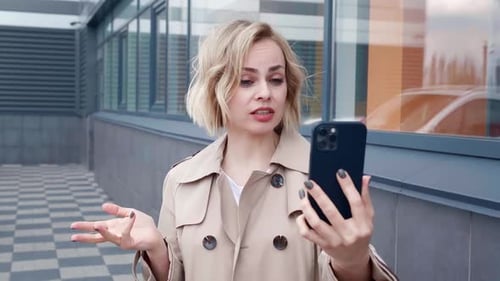 Woman Video Chatting on Phone Outdoors in Urban Setting