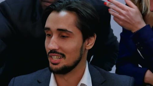 Young Businessman in the Center of Group of Multi Racial Business People in Meeting Talking