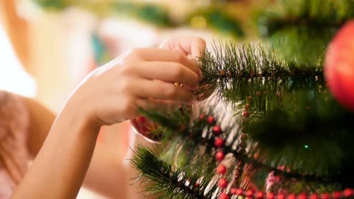 Child Decorating Christmas Tree with Ornaments at Home
