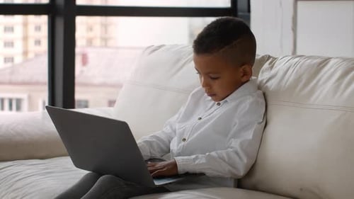 Boy on Couch Using Laptop Computer