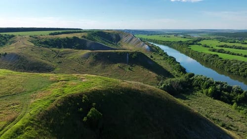 Drohnenansicht von Green Hills Flüssen und Feldern bei sonnigem Wetter