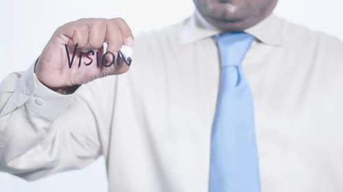 Man Writes 'Vision' on Transparent Surface