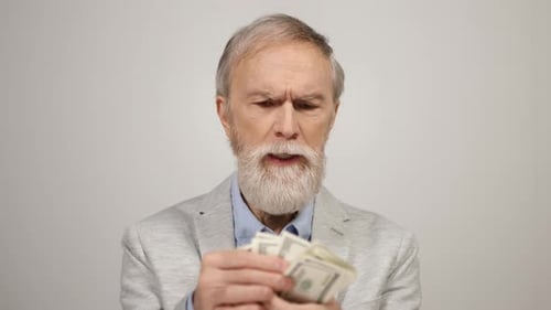 Old Man Counting Money Indoors