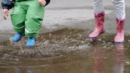 Funny Kid in Rain Boots Playing in a Rain Park