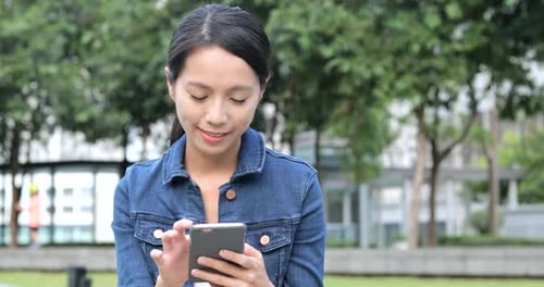 Woman using cellphone at outdoor park
