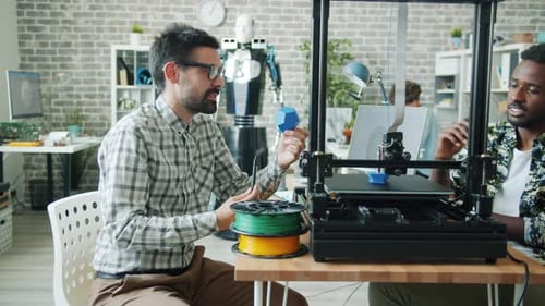 Slow Motion of Guys Discussing 3D Printing Process in Office Watching Equipment