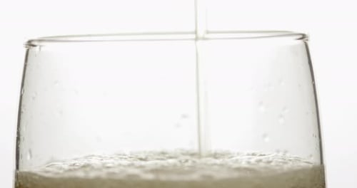 Pouring Cold Golden Light Beer Into a Glass. Craft Beer Making Bubbles and Foam