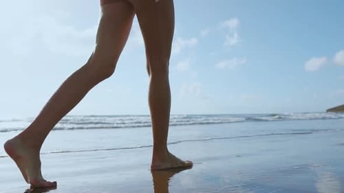 Woman Bare Foot Walking on the Summer Beach. Close Up Leg of Young Woman Walking Along Wave of Sea
