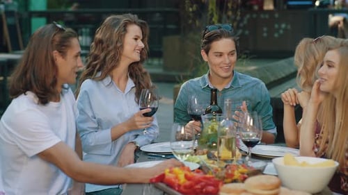 Friends Enjoying Outdoor Meal With Wine