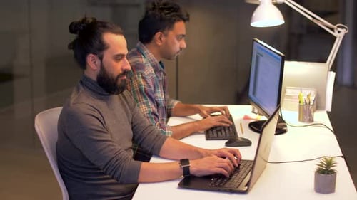 Programmierer mit Computern, die spät bei Office 21 arbeiten