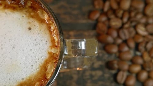 Close-up of Frothy Coffee with Roasted Beans