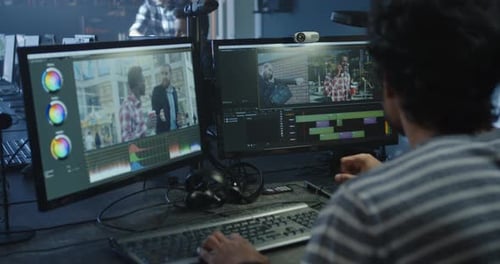 Video Editor Working at Dual Monitor Computer Station