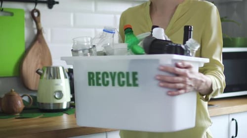 Woman Recycling Plastics in Kitchen at Home