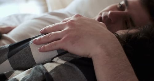 Affectionate Couple Cuddling in Bed at Home