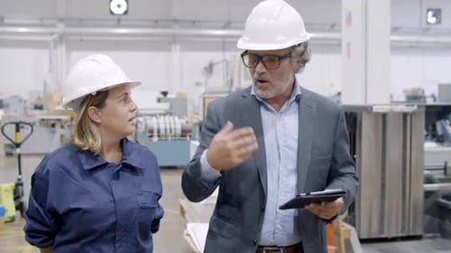 Senior Factory Boss with Tablet Commenting Machinery Work