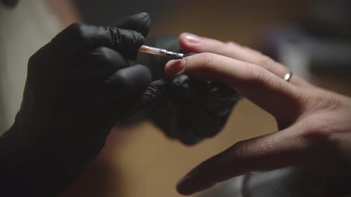 Manicurist Applies Clear Coat Nail Polish with Precision