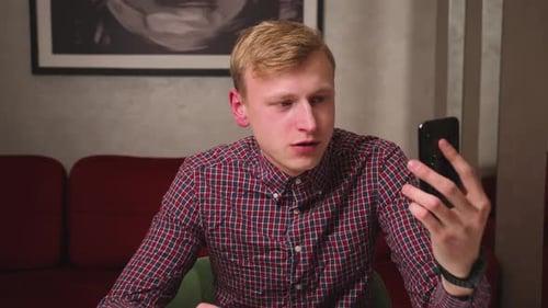 Young Adult Talking on Smartphone in Home Interior