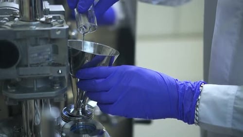 Pouring Liquid into Metal Funnel in Lab