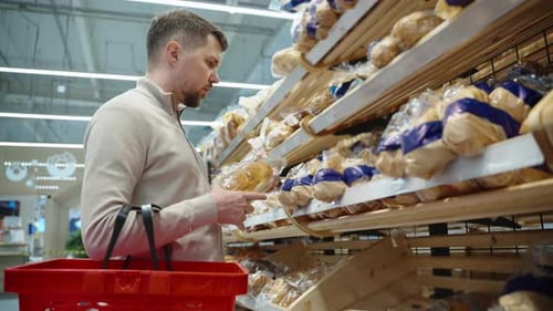 Aisle with Bread in Supermarket Man is Shopping Alone in Grocery